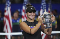 FILE - In this Sept. 7, 2019, file photo, Bianca Andreescu, of Canada, holds up the championship trophy after defeating Serena Williams, of the United States, in the women's singles final of the U.S. Open tennis championships in New York. The U.S. Tennis Association intends to hold the U.S. Open Grand Slam tournament in New York starting in August without spectators, if it gets governmental support -- and a formal announcement could come this week.(AP Photo/Charles Krupa, File)