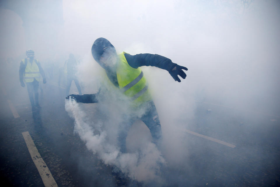 Tear gas fills the air as a protester wearing a yellow vest, a symbol of a French drivers’ protest against higher diesel taxes, demonstrates near the Place de l’Etoile in Paris, Dec. 1, 2018. (Photo: Stephane Mahe/Reuters)