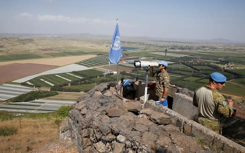 A United Nations Truce Supervision Organisation military observer uses binoculars near the border with Syria in the Israeli-occupied Golan Heights - Credit: BAZ RATNER/Reuters