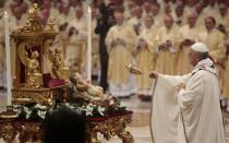 Pope Francis asperges incense on the baby Jesus statue as he leads the Christmas night mass in the Saint Peter's Basilica at the Vatican December 24, 2013. REUTERS/Tony Gentile