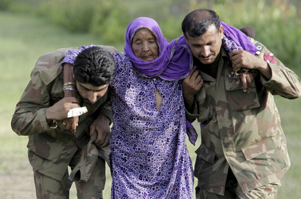 FILE - In this July 30, 2010, file photo, Pakistani army soldiers help an elderly villager evacuated from a flooded area in Nowshera, Pakistan. As Turkish forces invaded northern Syria in early October 2019, supporters of the offensive launched an online misinformation campaign. Dozens of misleading images claiming to show Turkey’s soldiers cuddling babies, feeding hungry toddlers and carrying elderly women, including this image from 2010, spread across Twitter and Instagram where they were liked, retweeted and viewed thousands of times. (AP Photo/Mohammad Sajjad, File)