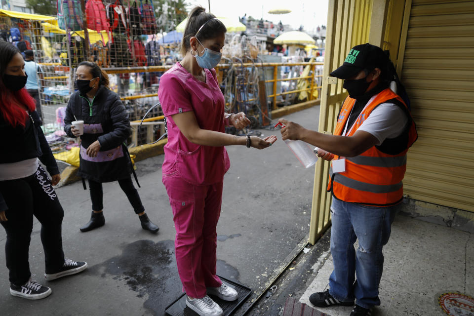 A shopper is given antibacterial gel as she enters Mercado Sonora, which reopened ten days ago with measures to reduce congestion and limit the spread of the coronavirus, in Mexico City, Thursday, June 25, 2020. (AP Photo/Rebecca Blackwell)