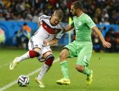 Germany's Bastian Schweinsteiger (L) fights for the ball with Algeria's Mehdi Lacen during extra time in their 2014 World Cup round of 16 game at the Beira Rio stadium in Porto Alegre June 30, 2014. REUTERS/Stefano Rellandini