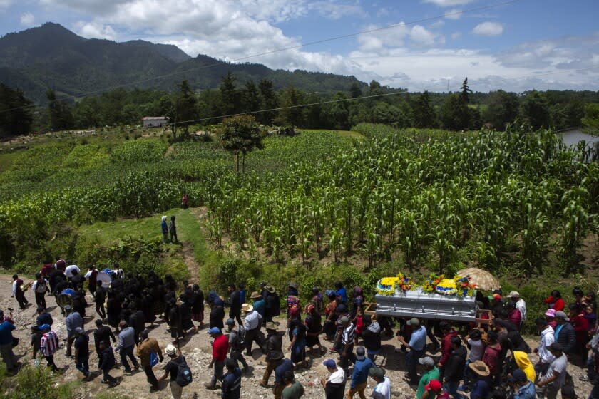 Vecinos y familiares cargan el féretro con los restos del adolescente Pascual Melvin Guachiac Sipac, rumbo al panteón de Tzucubal, en Nahualá, Guatemala, el sábado 16 de julio de 2022. El adolescente de 13 años formaba parte de un grupo de migrantes que murieron asfixiados el 27 de junio en el interior de un tráiler en San Antonio, Texas, en su intento por vivir en Estados Unidos. (AP Foto/Oliver de Ros)