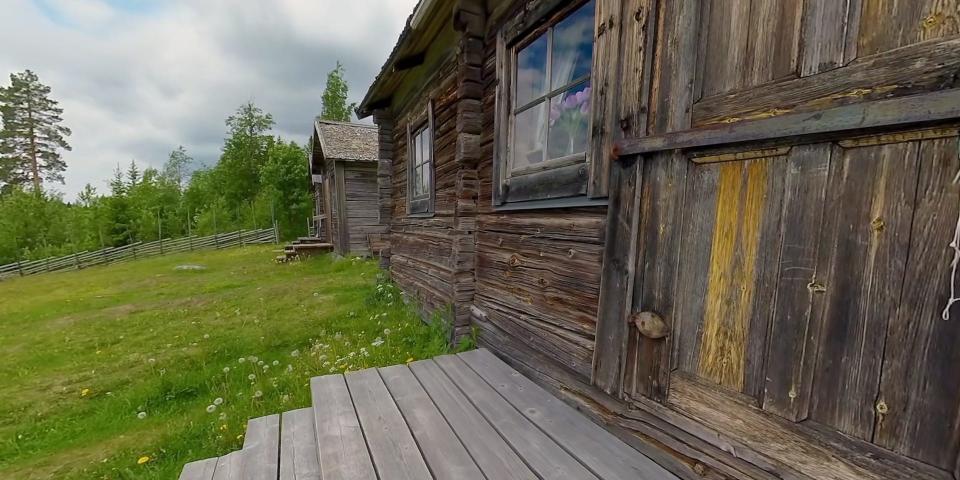 A cabin on a green field.