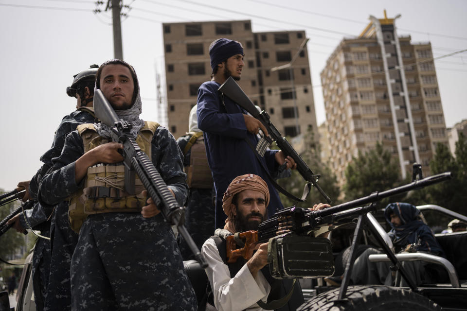 Taliban fighters escort women march in support of the Taliban government outside Kabul University, Afghanistan, on Saturday, Sept. 11, 2021. (AP Photo/Bernat Armangue)