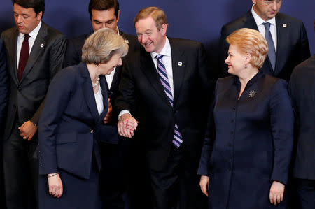 Britain's Prime Minister Theresa May greets Ireland's Prime Minister Enda Kenny next to Lithuania's President Dalia Grybauskaite as they pose for a family photo during a European Union leaders summit in Brussels, Belgium, October 20, 2016. REUTERS/Francois Lenoir