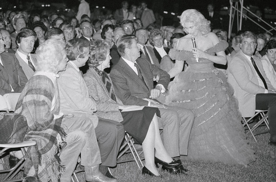 Singer Tammy Wynette coaxes President Ronald Reagan to his feet during a barbecue for members of Congress on the South Lawn of the White House on Sept. 30, 1982. / Credit: Bettmann / Getty Images