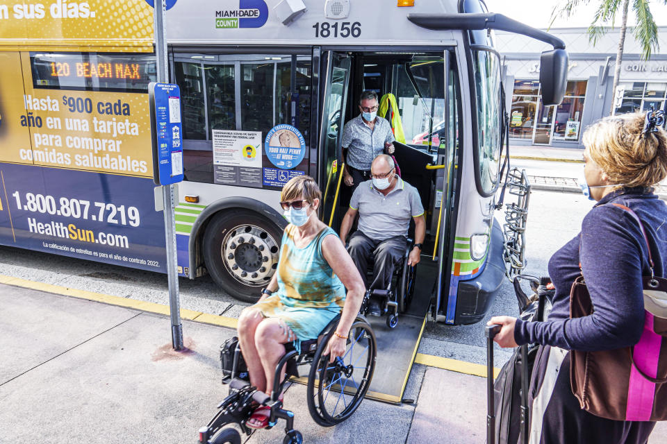  disabled woman and man get off a Miami-Dade County Metrobus.