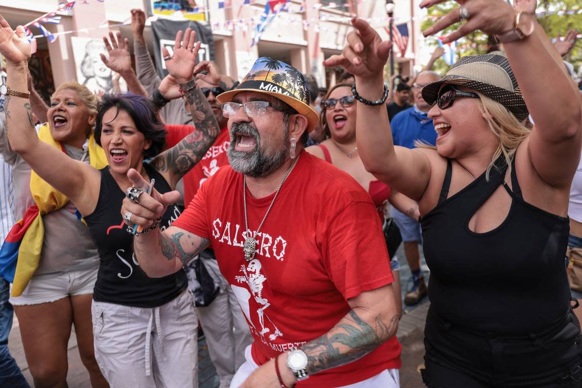 Alejandro Rocha, 47, center, and his wife, Gema Garcia, 41, right, and friends participate in the call and repeat by the band Diamente. After two years’ hiatus due to the COVID-19 pandemic, Calle Ocho is back with revelers enjoying music and food while vendors hawked their wares down SW 8th Street in Miami’s Little Havana neighborhood on Sunday, March 13, 2022.
