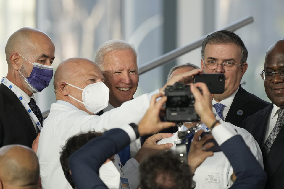 U.S. President Joe Biden poses for a selfie with medical personnel and other world leaders during a group photo at the La Nuvola conference center for the G20 summit in Rome, Saturday, Oct. 30, 2021. The two-day Group of 20 summit is the first in-person gathering of leaders of the world's biggest economies since the COVID-19 pandemic started. (AP Photo/Gregorio Borgia)