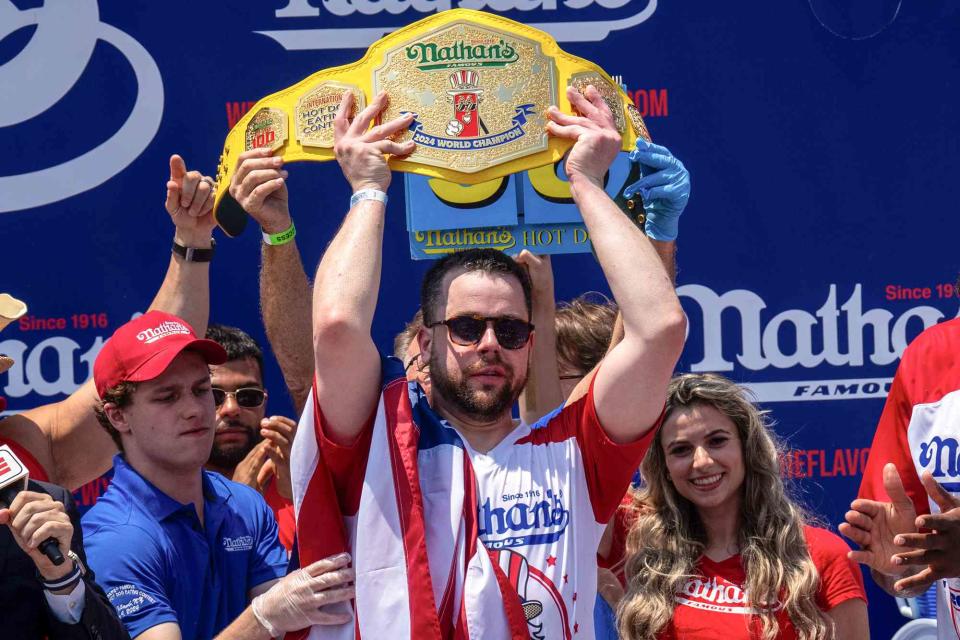 <p> Adam Gray/Getty</p> Patrick Bertoletti wins the mens title with 58 hotdogs at Nathan