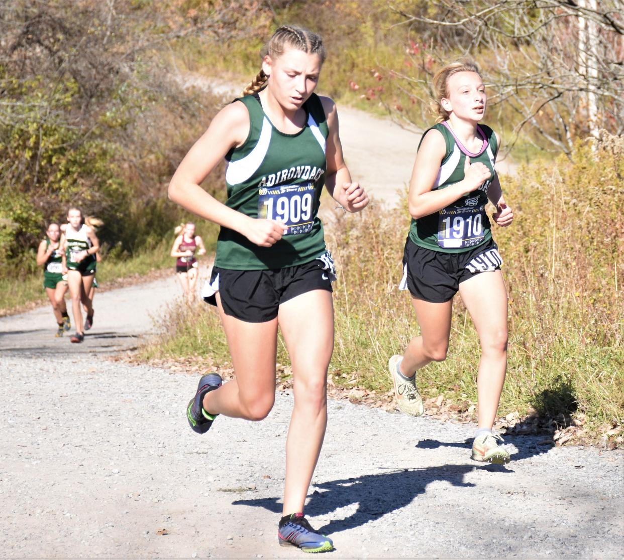 Adirondack Wildcats Kaylee Mathis and Johannah Northrop (from left) reach the the top of the final hill on a Herkimer College course during the 2022 Center State Conference championship meet. Mathis, Northrop and the Wildcats finished second in the Class C team competition at Saturday's state meet.