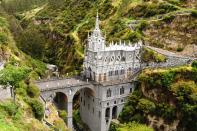 <p>Spanning across a forested gorge on the border of Colombia and Ecuador, <a href="http://santuariolavirgendelaslajas.com/index.html" rel="nofollow noopener" target="_blank" data-ylk="slk:La Lajas Sanctuary;elm:context_link;itc:0;sec:content-canvas" class="link ">La Lajas Sanctuary</a> boasts an origin story as miraculous as its location. The tale says that Amerindian Maria Meneses de Quiñones and her deaf-mute daughter Rosa found themselves caught in a brutal storm near the gorge in 1754. Hiding under the rocks, the women saw an illuminated figure thought to be the Virgin Mary above the rocks. Instantaneously, Rosa was able both hear and speak, and their story spread throughout the region. After reports of similar miracles happening to those who visited Las Lajas, it was decided in 1916 a neo-Gothic church would be built among the green cliffs and cascading waterfall.</p>