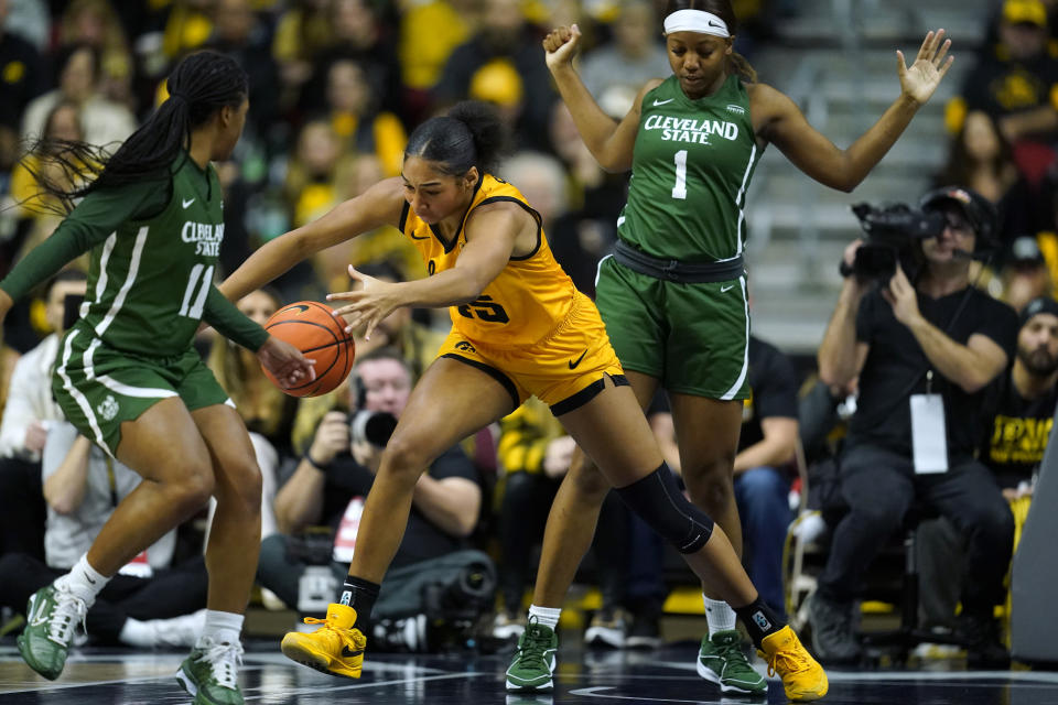 Iowa forward Hannah Stuelke (45) runs down a loose ball between Cleveland State guard Colbi Maples (11) and forward Brooklynn Fort-Davis (1) during the first half of an NCAA college basketball game, Saturday, Dec. 16, 2023, in Des Moines, Iowa. (AP Photo/Charlie Neibergall)