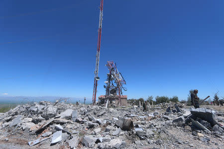 Members of the Kurdish People's Protection Units (YPG) inspect the damage at their headquarters after it was hit by Turkish airstrikes in Mount Karachok near Malikiya, Syria. REUTERS/ Rodi Said