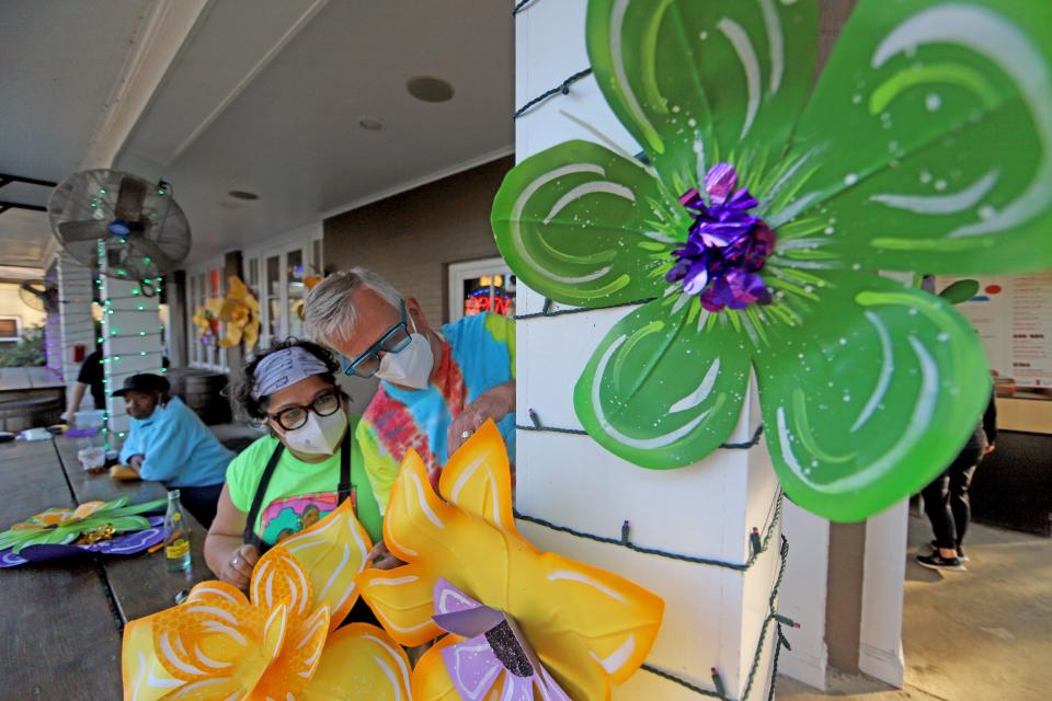 Artists Re Howse (L) and Bill Tucker (R) decorate the Backyard, a BBQ restaurant in Lakeview, with giant flowers they created as businesses get in on the Carnival house float trend. Photographed on Friday, January 14, 2022. (Photo by Michael DeMocker)