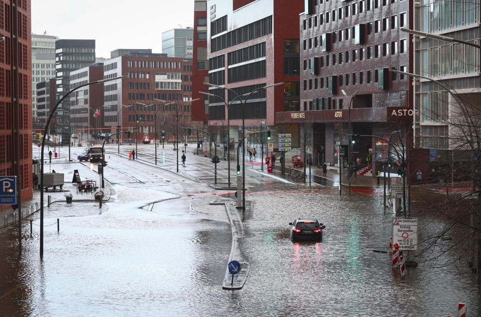 A stranded vehicle on the flooded street in Hafencity, Hamburg, Germany, Friday Dec. 22, 2023. There is a risk of a severe storm surge for the German North Sea coast and Hamburg on Friday. (Christian Charisius/dpa via AP)