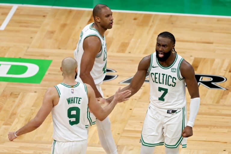 Jaylen Brown (centro) celebra una canasta de los Celtics con Derrick White y Al Horford. (Adam Glanzman)