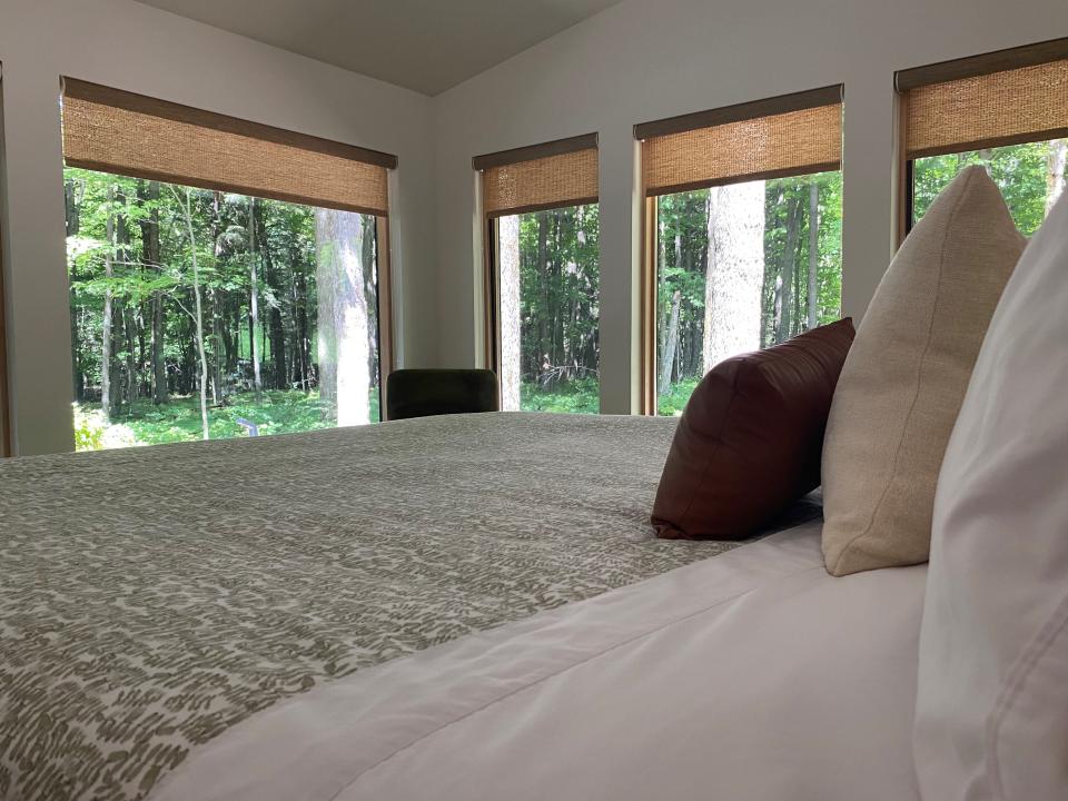 The windows of the bedroom of Owl Ridge Cabin offer views of the woods that surround the lodging.
