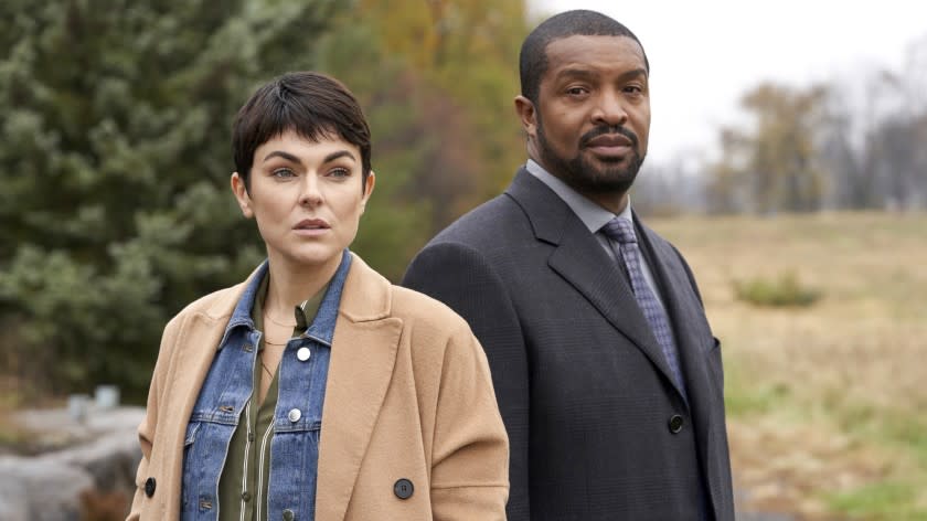 Coroner -- The CW TV Series, Coroner -- "Bridges" -- Image Number: COR108_1000r.jpg -- Pictured (L-R): Serinda Swan as Dr. Jenny Cooper and Roger Cross as Detective Donovan "Mac" McAvoy -- Photo: © 2020 Muse Entertainment Enterprises, Inc. Serinda Swan and Roger Cross in "Coroner" on The CW.