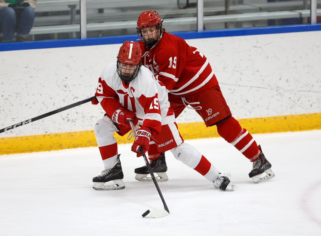 Penfield’s Sean Walsh carries the puck around Hilton’s Luke Manley.