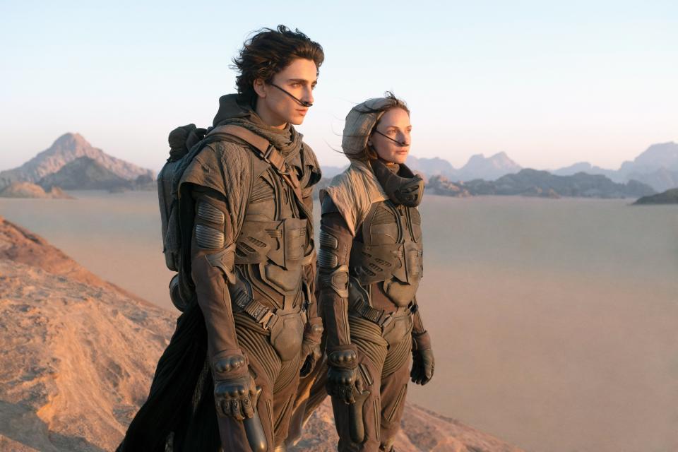 Timothee Chalamet and Rebecca Ferguson stand on a sand dune