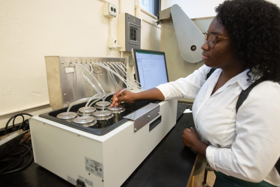 India Myers, of Oakwood University in Alabama, connects hoses to various containers of dough made with Kernza grain at a lab in Waters Hall at Kansas State University.