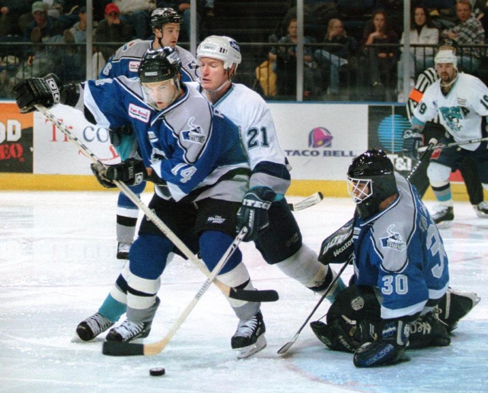 BC Icemen's Patrice Robitaille battles for control of the puck in front of goalie Erasmo Saltarelli during a game in 1999.