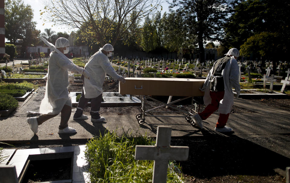 Trabajadores funerarios trasladan el ataúd de una víctima de COVID-19 en un cementerio de Buenos Aires, Argentina, el sábado 8 de mayo de 2021. En Argentina se registran hasta ahora algo más de 3,1 millones de enfermos y más de 67.000 fallecidos. (AP Foto/Natacha Pisarenko)