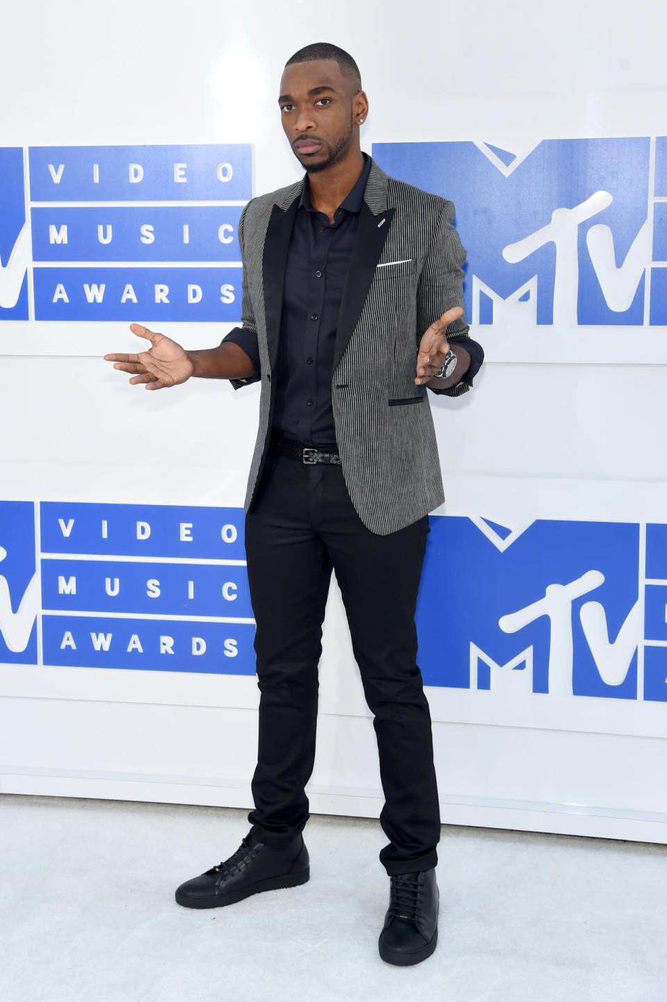 Jay Pharoah combining a navy blue button-down shirt with a black-and-white striped blazer. 