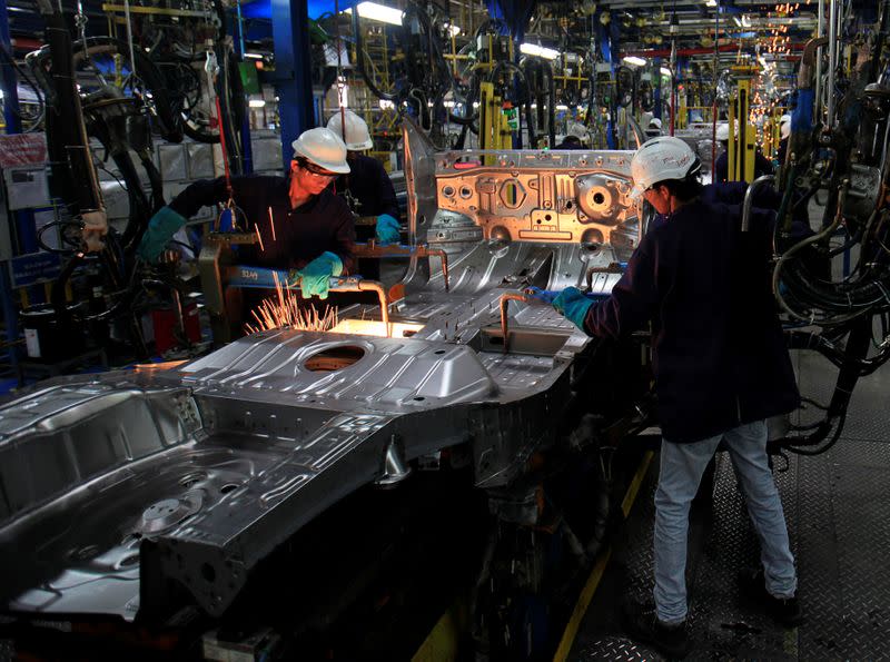 FILE PHOTO: Employees work on the assembly line at the General Motors plant in Talegaon