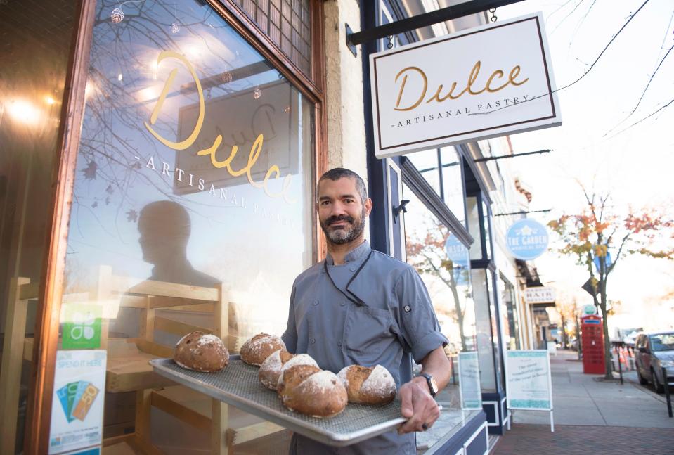 Josué Santiago Negrón, owner and chef of Dulce Artisanal Pastry in Collingswood, displays freshly made  loaves of fig and hazelnut bread.