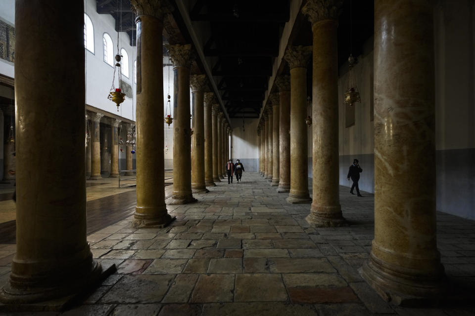 FILE - People visit the Church of the Nativity, traditionally believed to be the birthplace of Jesus Christ, on Christmas Eve in the West Bank city of Bethlehem, Friday, Dec. 24, 2021. U.S. President Joe Biden's dash through the Israel and the occupied West Bank this week is expected to cut across some of the region's most iconic places. Both luxurious and grueling, Biden's visit starts with a VIP arrival at Israel's main commercial airport and pings through Jerusalem and the occupied West Bank. In between his meetings with Israeli and Palestinian leaders, he will visit a host of well-known sites while staying at a historic Jerusalem hotel. (AP Photo/Majdi Mohammed, File)