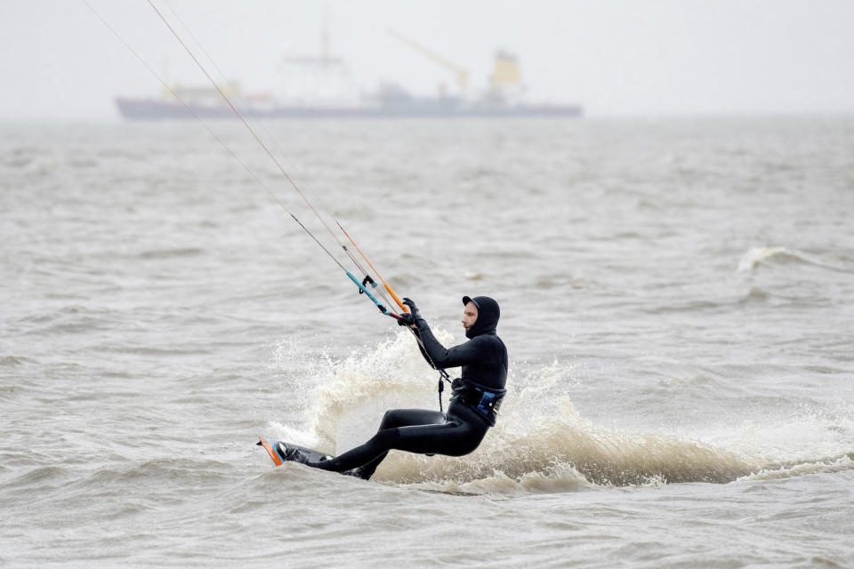 A kitesurfer is out on the North Sea in stormy weather near Schillig, Germany, Friday, Feb. 18, 2022. After a short intermediate high, the hurricane "Zeynep" is expected to sweep across Lower Saxony from the west in the course of the day. (Hauke-Christian Dittrich/dpa via AP)