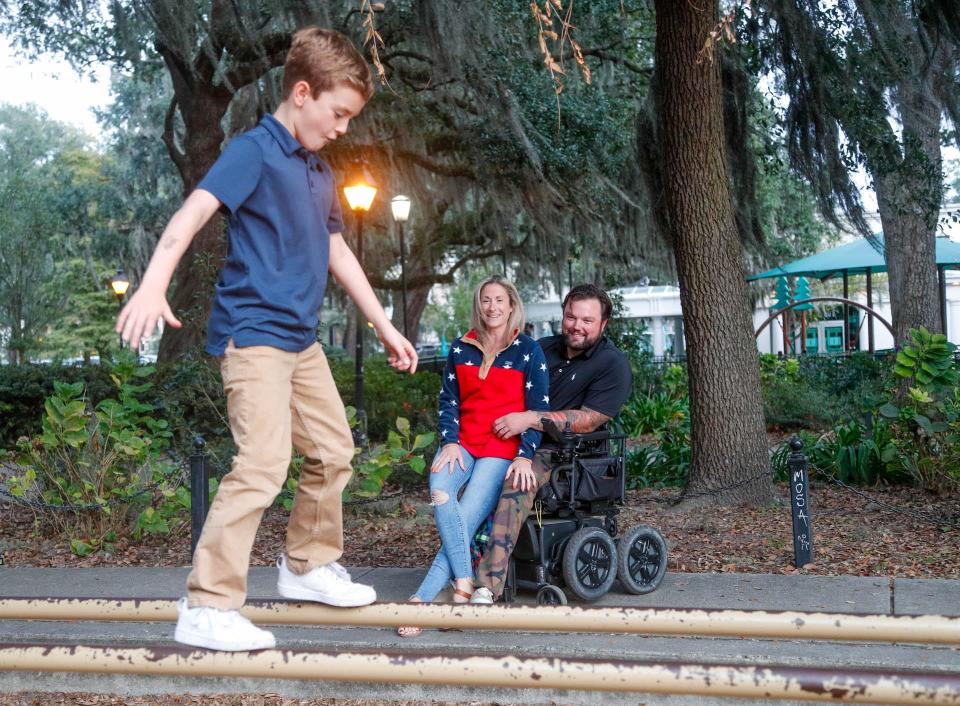 Sgt.1st Class Ryan Davis holds his wife Asia as they watch their son Knox balance on the parallel bars on the playground at Forsyth Park in Savannah Georgia. Ryan lost 3 limbs and has gone through around 60 surgeries since suffering a severe injury froma blast while on a mission in Afghanistan with the U.S. Army 1st Ranger Battalion. in August 2019.