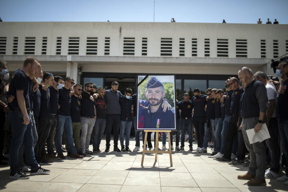 Police officers pay homage to a slain colleague at a police station in Avignon, southern France, Sunday, May 9, 2021. Police officers and civilians gathered to commemorate the death of a police officer who was killed Wednesday at a known drug-dealing site in the southern France city of Avignon. (AP Photo/Daniel Cole)