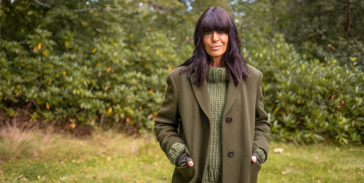 claudia winkleman the traitors wearing green knitted jumper and coat