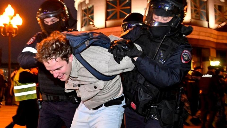 Dos policías antidisturbios someten a un manifestante.