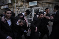 Ultra-Orthodox Jews celebrate during the Jewish holiday of Purim, in the Mea Shearim ultra-Orthodox neighborhood of Jerusalem, Sunday, Feb. 28, 2021. The Jewish holiday of Purim commemorates the Jews' salvation from genocide in ancient Persia, as recounted in the biblical Book of Esther. (AP Photo/Oded Balilty)