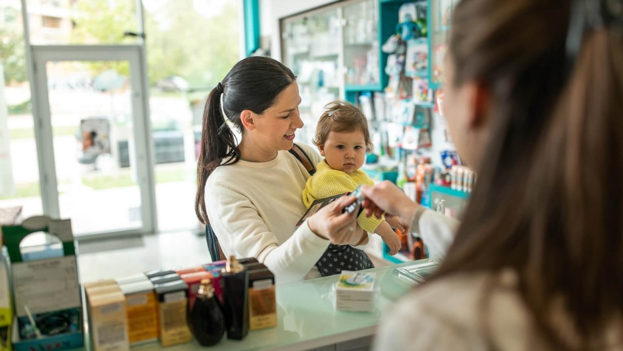 Caucasian mom talks with pharmacist.