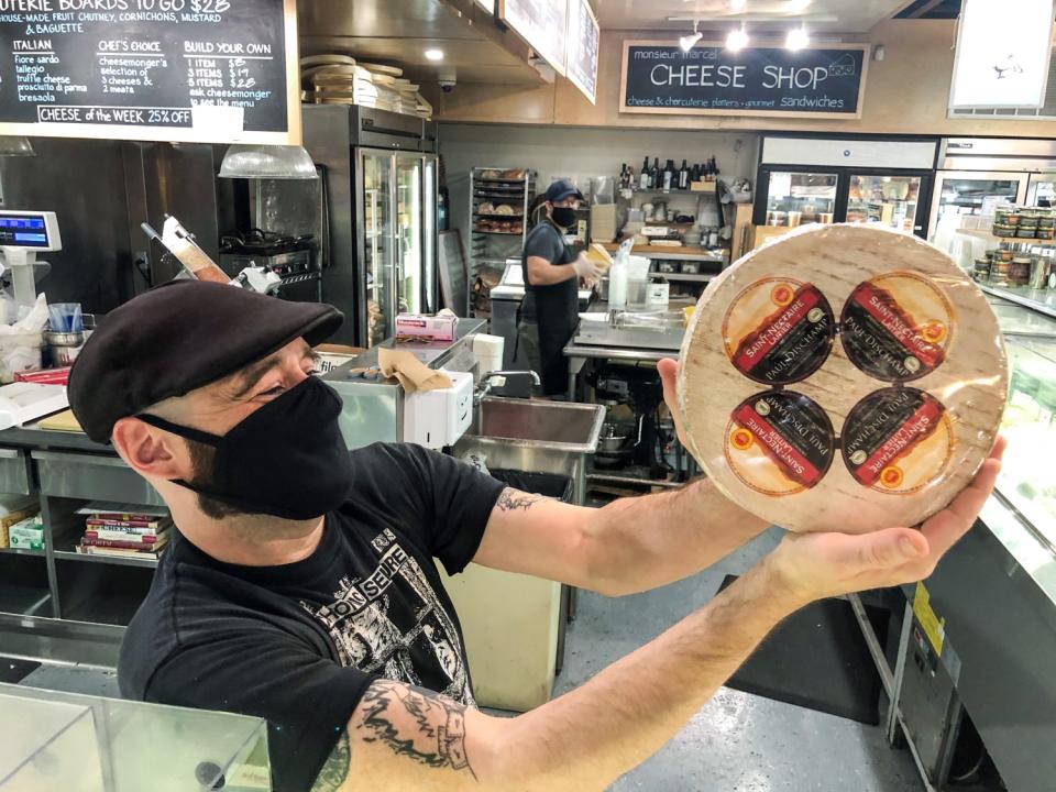 A Monsieur Marcel employee holds up a sample of the goods at the French market