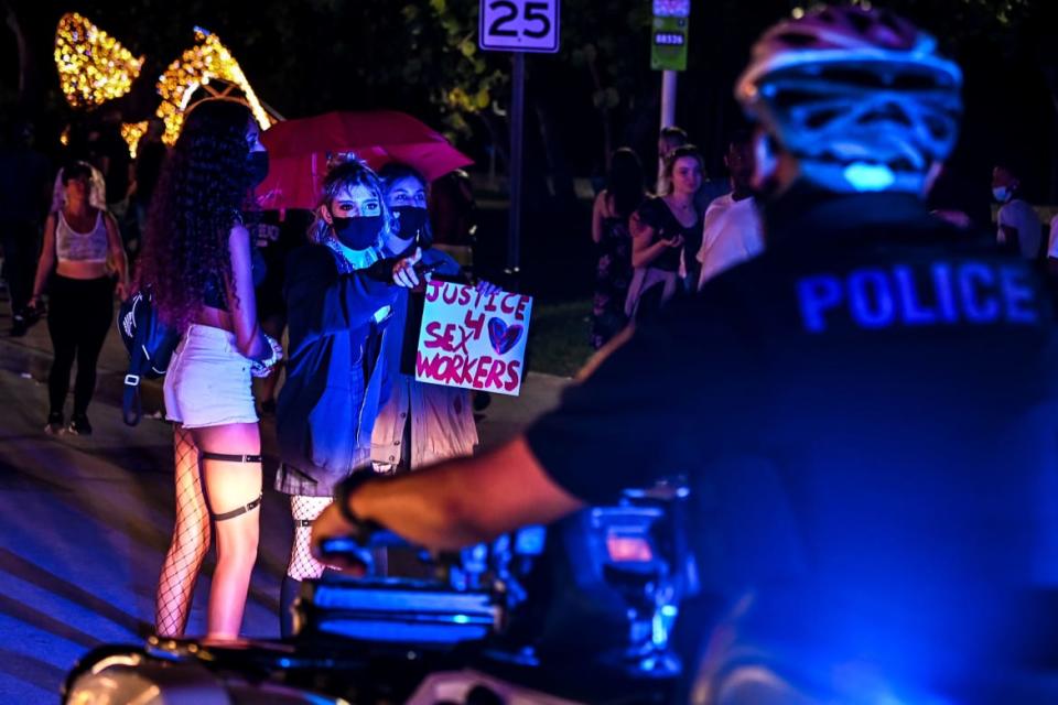 <div class="inline-image__caption"><p>Activists and sex workers hold up signs near police as they protest for the decriminalization of sex work in Miami Beach, Florida, on December 5, 2020.</p></div> <div class="inline-image__credit">Chandan Khanna/AFP/Getty</div>