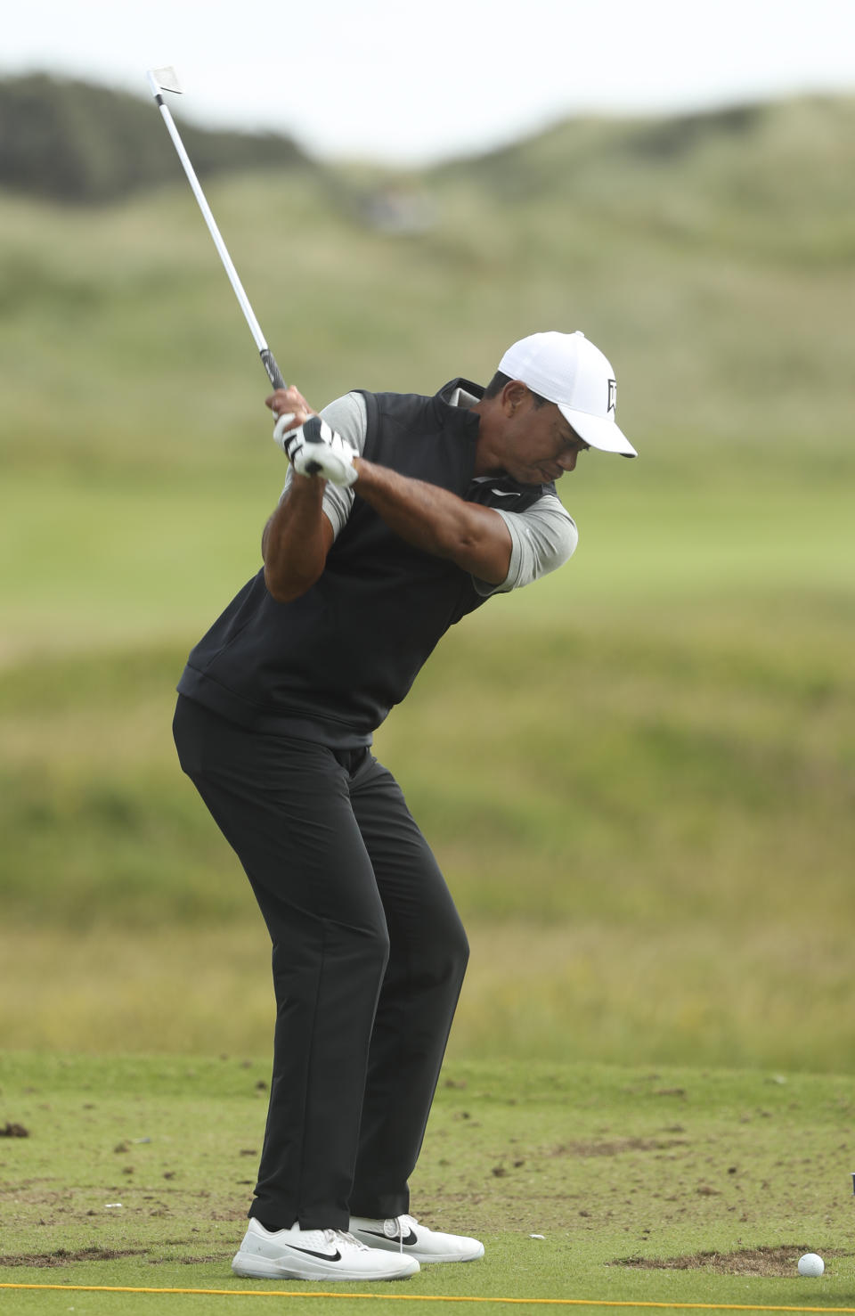 Tiger Woods of the United States hits a shot at the practice ground ahead of the start of the British Open golf championships at Royal Portrush in Northern Ireland, Tuesday, July 16, 2019. The British Open starts Thursday. (AP Photo/Jon Super)