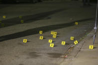 Evidence markers line the street outside a house on Carolina Avenue after a shooting, late Thursday, May 13, 2021, in Providence, R.I. (AP Photo/Stew Milne)