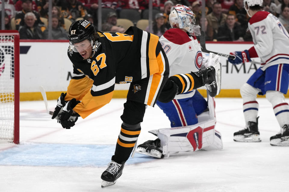 Pittsburgh Penguins' Rickard Rakell (67) trips over the stick of Montreal Canadiens goaltender Cayden Primeau during the second period of an NHL hockey game in Pittsburgh, Thursday, Feb. 22, 2024. (AP Photo/Gene J. Puskar)