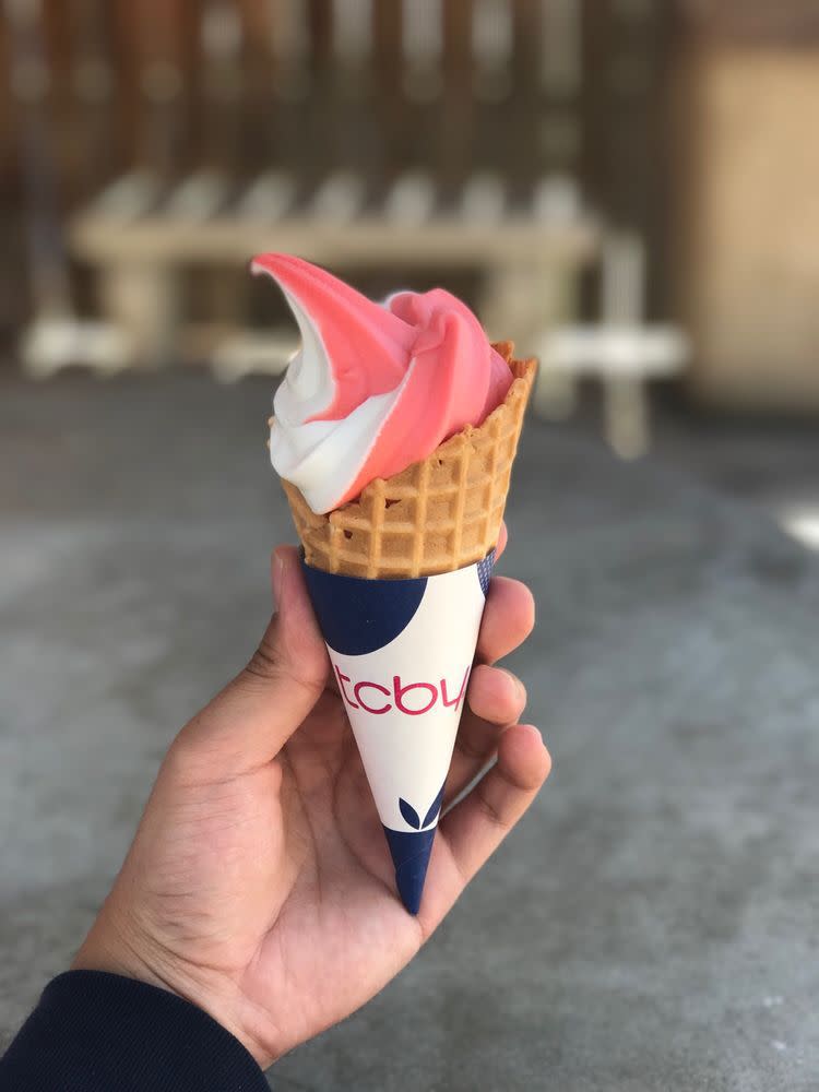 Pink and white frozen yogurt in a waffle cone from TCBY