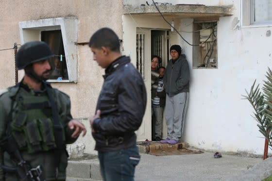 Israeli soldiers question Palestinians and search houses in the village of al-Tabaqa, near Dura in the southern West Bank region of Hebron, on Feb. 16, 2012. <span class="copyright">Hazem Bader—AFP/Getty Images</span>