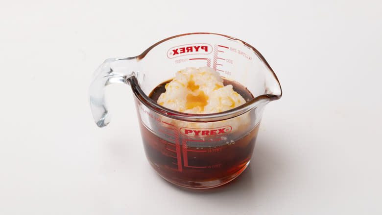 Coconut oil and maple syrup in glass measuring cup