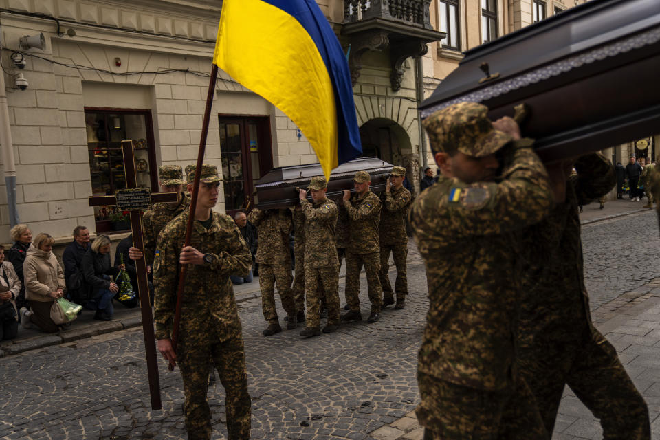 Soldiers carry the coffins of two Ukrainian army sergeants Tomkevych Mykhailo and Kril Olexander during their funeral at the Saints Peter and Paul church in Lviv, Ukraine, Tuesday, April 16, 2024. (AP Photo/Francisco Seco)